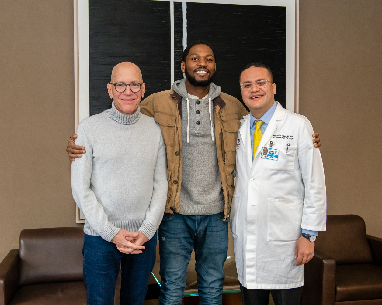 Noel poses with Drs. Adams and El-Eshmawi weeks after his surgery during his follow-up visit.